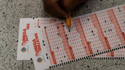 Prince Joseph Israel fills out Mega Millions playslips at Blue Bird Liquor in Hawthorne, Calif., Tuesday, July 26, 2022. (AP Photo/Jae C. Hong)