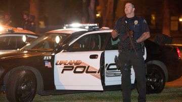 Police respond in Riverside, Calif., early Thursday morning, Feb. 7, 2013, after one officer was killed and another critically wounded in a shoot out with a murder suspect. Police were searching for a former Los Angeles police officer sought for two weekend killings  and who threatened to kill police. (AP Photo/Kevin Warn)