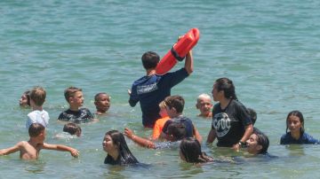 A Los Angeles County Lifeguard keeps children safe as they cool off at Castaic Lake as temperatures rise, Monday, July 8, 2024, in Castaic, Calif. (AP Photo/Damian Dovarganes)
