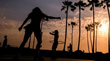 People are silhouetted as they workout during sunset on Wednesday, June 16, 2021, in the Venice Beach section of Los Angeles. An unusually early and long-lasting heat wave brought more triple-digit temperatures Wednesday to a large swath of the U.S. West, raising concerns that such extreme weather could become the new normal amid a decades-long drought. (AP Photo/Ringo H.W. Chiu)