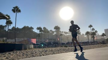RETRANSMISSION TO CORRECT YEAR TO 2022 - A runner is silhouetted under the rising sun on a hot morning Friday, Sept. 2, 2022 in Santa Monica, Calif. (AP Photo/Brian Melley)