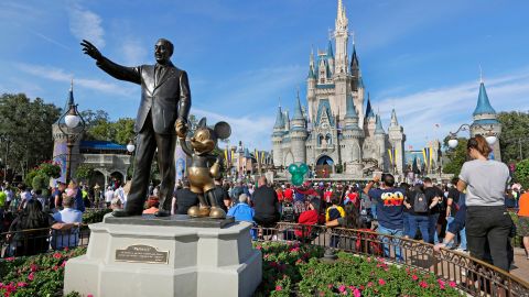 FILE - In this Jan. 9, 2019 file photo, guests watch a show near a statue of Walt Disney and Micky Mouse in front of the Cinderella Castle at the Magic Kingdom at Walt Disney World in Lake Buena Vista, part of the Orlando area in Fla. Magic Kingdom was the best-attended park in 2018 with 20.8 million visitors, followed by Disneyland in California with 18.6 million visitors. (AP Photo/John Raoux, File)