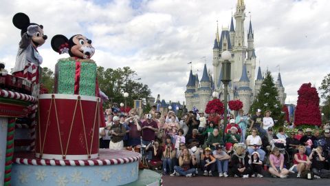 ** FILE ** Visitors gather in front of Cinderella's castle to watch Mickey and Minnie Mouse during the Christmas parade at Walt Disney World's Magic Kingdom in Lake Buena Vista, Fla, Dec. 22, 2004. A group of seven friends from Sydney _ all Disney fanatics organized a 32-day trip that takes them to every Disney park in the world _ from Tokyo to Hong Kong to Paris, to the U.S. flagships, Disneyland in Anaheim, Calif., and Walt Disney World near Orlando, Fla. (AP Photo/Peter Cosgrove)