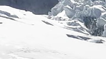This photo distributed by the Peruvian National Police shows officers surrounding the body of who they identify as U.S. mountain climber William Stampfl, on Huascaran mountain in Huaraz, Peru, July 5, 2024. Peruvian authorities announced on Tuesday, July 9, 2024, that they have found the mummified body of the American man who died 22 years ago, along with two other American climbers, after the three were trapped in an avalanche while trying to climb Peru's highest mountain. (Peruvian National Police via AP)