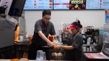 Lawrence Cheng, left, whose family owns seven Wendy's locations south of Los Angeles, works with part-time employee Adriana Ruiz at his Wendy's restaurant in Fountain Valley, Calif., June 20, 2024. When California’s minimum wage increase went into effect in April, fast food workers across the state went from making $16 to $20 overnight. It's already having an impact, according to local operators for major fast food chains, who say they are reducing worker hours and raising menu prices as the sudden increase in labor costs leaves them scrambling for solutions. (AP Photo/Jae C. Hong)