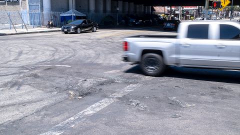 Una vista del área donde dos carros quedaron en llamas después de que un grupo de jóvenes bloqueara una calle en Los Ángeles.