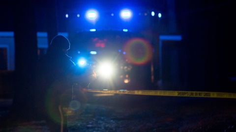 A law enforcement official removes police tape at a house Tuesday, Jan. 6, 2015, on Ridge Road near Douglasville, Ga., where a shooting took place. Cpl. Sam Driskell was found fatally shot along with his wife, daughter and stepson, sheriff's spokesman Ashley Henson said. (AP Photo/Kevin Liles)