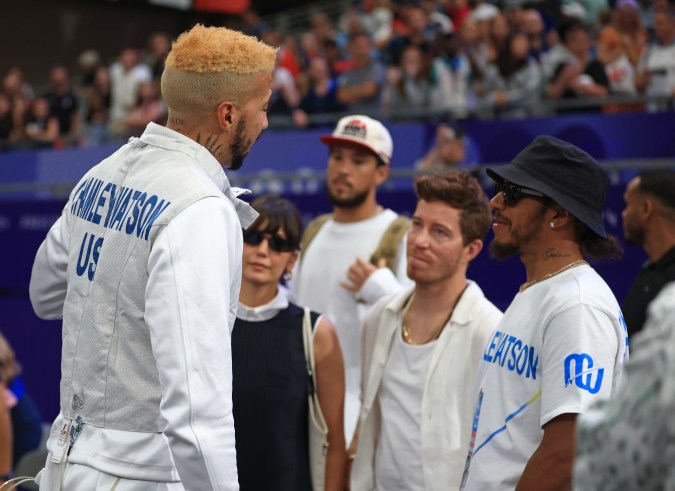 Lewis Hamilton junto a la modelo Nina Dobrev y el ex patinador profesional estadounidense Shaun White conversando con el esgrimista Miles Chamley-Watson.
