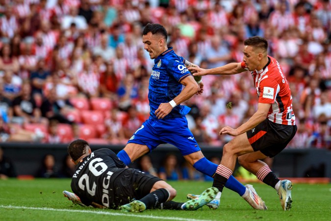 El delantero del Getafe, Álex Sola, intenta llevarse al balón ante el portero del Athletic Club, Alex Padilla, durante el partido de la primera fecha de LaLiga disputado el jueves en San Mamés.