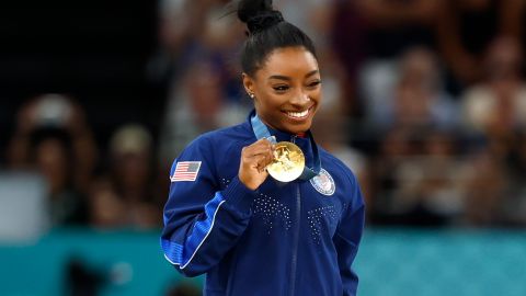 Simone Biles posando con su medalla de oro, la más reciente en su impresionante palmarés en los Juegos Olímpicos.