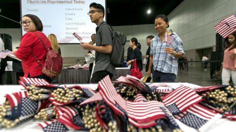 Immigrants pick flags as they arrive to take their citizenship oath during naturalization ceremonies at a U.S. Citizenship and Immigration Services (USCIS) ceremony in Los Angeles Wednesday, Sept. 20, 2017. Immigrants who want to become U.S. citizens generally must have been legal permanent residents of the United States for at least three years, show "good moral character" and pass English and civics tests that cover topics such as the Founding Fathers, Constitution and the presidency. (AP Photo/Damian Dovarganes)