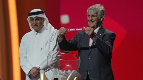 Serbian-Mexican retired soccer manager Bora Milutinovic holds up the name of Saudi Arabia as he assists in the 2022 soccer World Cup draw at the Doha Exhibition and Convention Center in Doha, Qatar, Friday, April 1, 2022. (AP Photo/Darko Bandic)