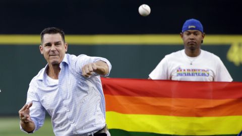 FILE - Billy Bean, Major League Baseball vice president of Social Responsibility & Inclusion, throws out the ceremonial first pitch to Seattle Mariners' Felix Hernandez before a baseball game between the Mariners and Milwaukee Brewers Friday, Aug. 19, 2016, in Seattle. Bean said he doesn't think the absence of an openly gay player is the right way to evaluate inclusivity in the major leagues, just like he doesn't think the sport should be evaluated by a comment that might not be supportive. Bean came out after his playing career. (AP Photo/Elaine Thompson, File)