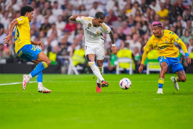 Real Madrid's Rodrygo, center, vies for the ball with Las Palmas' Saul Coco, left, and Julian Araujo during a Spanish La Liga soccer match between Real Madrid and Las Palmas, at Santiago Bernabeu stadium, in Madrid, Wednesday, Sept. 27, 2023. Joselu scored once in Real Madrid's 2-0 victory. (AP Photo/Manu Fernandez)