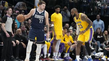 Dallas Mavericks guard Luka Doncic (77) dribbles against Los Angeles Lakers forward LeBron James (23) during the second half of an NBA basketball game in Dallas, Tuesday, Dec. 12, 2023. (AP Photo/LM Otero)