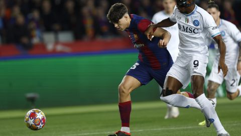 Napoli's Victor Osimhen, right, challenges Barcelona's Pau Cubarsi during the Champions League, round of 16, second leg soccer match between FC Barcelona and SSC Napoli at the Olympic Stadium in Barcelona, Spain, Tuesday, March 12, 2024. (AP Photo/Joan Monfort)