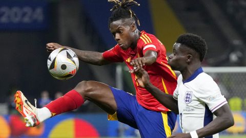 Spain's Nico Williams vies for the ball with England's Bukayo Saka, right, during the final match between Spain and England at the Euro 2024 soccer tournament in Berlin, Germany, Sunday, July 14, 2024. (AP Photo/Manu Fernandez)