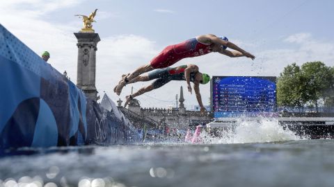 Chile's Diego Maya, right, and Portugal's Vasco Vilaca dive back into the Seine river for the second lap of the swim portion at the men's individual triathlon competition at the 2024 Summer Olympics, Wednesday, July 31, 2024, in Paris, France. (AP Photo/David Goldmanl)