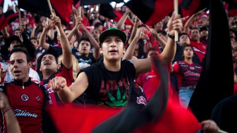 In this Oct. 7, 2012 photo, fans of the soccer team Xoloitzcuintles of Tijuana, or Xolos, cheer for their team at Caliente stadium as they play Toluca in Tijuana, Mexico. The Xolos soccer team has become a sensation in Tijuana since they joined Mexico's first division soccer league in 2011. (AP Photo/Alex Cossio)