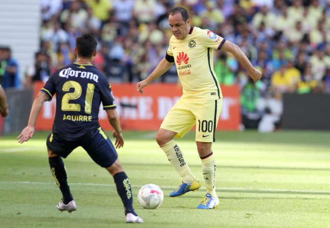 America´s Cuauhtemoc Blanco, right, dribbles the ball under the pressure of Morelia´s Erick Aguirre, during a Mexican soccer league match, in Mexico City, Saturday, March 5, 2016. (AP Photo/Christian Palma)
