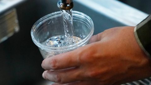 A cup of water is drawn from a faucet at Johnny T's Bistro and Blues, a midtown Jackson, Miss., restaurant and entertainment venue, Thursday, Sept. 1, 2022. Although it is no longer cloudy, owner John Tierre says he has concerns over the city's longstanding water problems. Some business owners report spending anywhere between $300 to $500 per day on ice and bottled water. (AP Photo/Rogelio V. Solis)