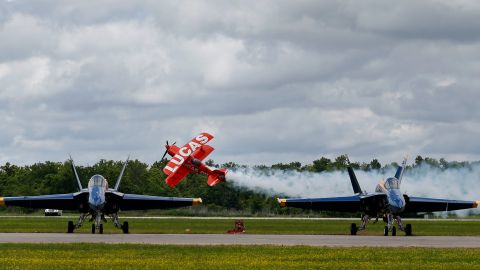 Lucas Oil sponsored Michael Wiskus performs aerobatics in his Pitts S-1-11B beyond waiting U.S. Navy Blue Angels FA-18 Hornets during the New Orleans Air Show at the Naval Air Station Joint Reserve Base in Belle Chasse, La., Sunday, April 23, 2017. (AP Photo/Gerald Herbert)