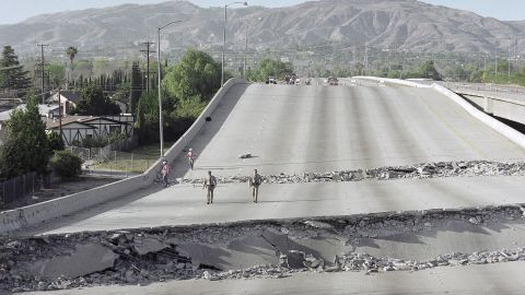 Two California Highway Patrol officers walk on a collapsed portion of eastbound Interstate 118 at Hayvenhurst Avenue in Grenada Hills, Calif., Jan. 17, 1994, after an earthquake measuring 6.6 on the Richter scale s truck Southern California. (AP Photo/Chuck Jackson)