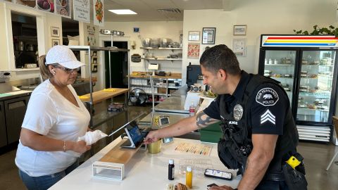 Alicia Acevedo, encargada del restaurante Flor de Lina Farms atiende a un oficial.