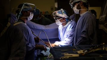 Dr. Sunil Singhal, center, directs a special camera to look at a patient's tumor, made visible with fluorescent dye, on monitors at the Hospital of the University of Pennsylvania in Philadelphia, Tuesday, Jan. 23, 2018. Researchers are testing fluorescent dyes that make cancer cells glow to make them easier for surgeons to find, giving patients a better shot at survival. (AP Photo/Matt Rourke)