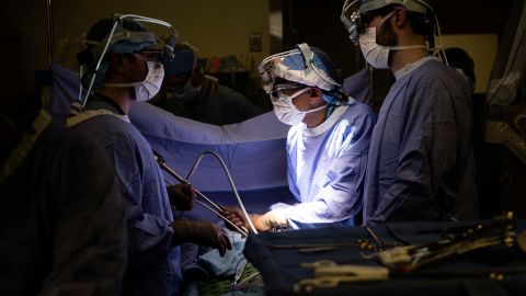 Dr. Sunil Singhal, center, directs a special camera to look at a patient's tumor, made visible with fluorescent dye, on monitors at the Hospital of the University of Pennsylvania in Philadelphia, Tuesday, Jan. 23, 2018. Researchers are testing fluorescent dyes that make cancer cells glow to make them easier for surgeons to find, giving patients a better shot at survival. (AP Photo/Matt Rourke)