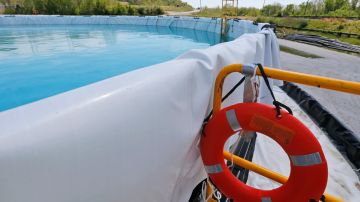 A life ring is on standby on a ladder at a tank with clean water from coal ash wastewater treatment retention tank prior to being pumped into the James river outside Dominion Powers Bremo Bluff power plant in Bremo Bluff, Va., Tuesday, April 26, 2016. The sediment in the tank is from James River water that was used to test the tank prior to use. (AP Photo/Steve Helber)