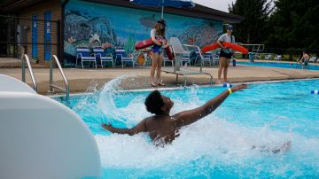 Lifeguards Hailey Landrun, 17, and Rachel Mees, 21, watch over swimmers at the Douglass Park pool in Indianapolis, Friday, June 17, 2022. Indianapolis typically fills 17 pools each year, but with a national lifeguard shortage exacerbated by the COVID-19 pandemic, just five are open this summer. The American Lifeguard Association estimates one-third of pools in the United States are impacted by the shortage. (AP Photo/Michael Conroy)