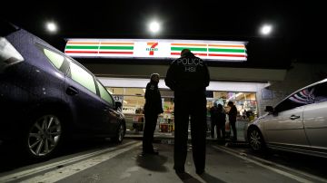 In this Jan. 10, 2018 photo U.S. Immigration and Customs Enforcement agents serve a employment audit notice at a 7-Eleven convenience store in Los Angeles. Agents targeted about 100 stores nationwide Wednesday to open employment audits and interview workers. (AP Photo/Chris Carlson)
