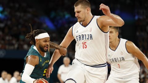 Paris (France), 06/08/2024.- Patty Mills of Australia (L) in action against Nikola Jokic of Serbia (R) during the Men quarterfinal match between Serbia and Australia of the Basketball competitions in the Paris 2024 Olympic Games, at the Bercy Arena in Paris, France, 06 August 2024. (Baloncesto, Francia) EFE/EPA/CAROLINE BREHMAN