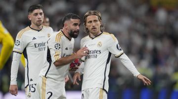 Real Madrid's Luka Modric, right, listens to Dani Carvajal, center, next to Federico Valverde during the Champions League final soccer match between Borussia Dortmund and Real Madrid at Wembley stadium in London, Saturday, June 1, 2024. (AP Photo/Kin Cheung)