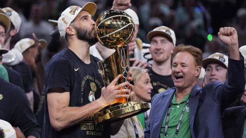 Boston Celtics forward Jayson Tatum kisses the Larry O'Brien Championship Trophy after Game 5 of the NBA Finals basketball series against the Dallas Mavericks, Monday, June 17, 2024, in Boston. At right is Celtics co-owner Stephen Pagliuca. (AP Photo/Charles Krupa, Pool)