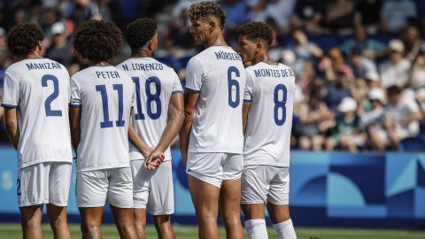 Dominican Republic's Firpo Junior places himself on the ground behind the wall formed by his teammates during the men's group C match between the Dominican Republic and Uzbekistan at the Parc des Princes during the 2024 Summer Olympics, Tuesday, July 30, 2024, in Paris, France. (AP Photo/Aurelien Morissard)