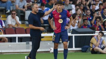 Barcelona's head coach Hansi Flick, left, gives instructions next to Pau Cubarsi during the Spanish La Liga soccer match between FC Barcelona and Valladolid at the Olympic stadium in Barcelona, Spain, Saturday, Aug. 31, 2024. (AP Photo/Joan Monfort)