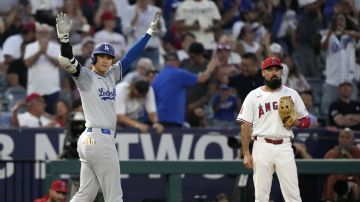 Shohei Ohtani, de los Dodgers, celebra tras conectar un triple productor en el tercer inning contra su exequipo, los Angels. Atestigua Anthony Rendón.