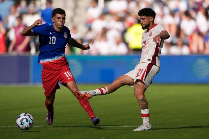 El mediocampista canadiense Jonathan Osorio disputa una jugada con el capitán de los estadounidenses, Christian Pulisic.