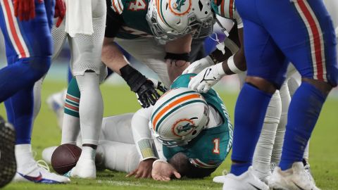 Miami Dolphins quarterback Tua Tagovailoa (1) is assisted on the field during the second half of an NFL football game against the Buffalo Bills, Thursday, Sept. 12, 2024, in Miami Gardens, Fla. (AP Photo/Rebecca Blackwell)