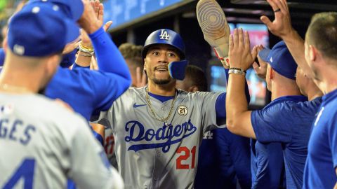 Los Angeles Dodgers' Mookie Betts wearing (21) in commemoration of Roberto Clemente celebrates scoring in the ninth inning of a baseball game against the Atlanta Braves, Sunday, Sept. 15, 2024, in Atlanta. (AP Photo/Jason Allen)