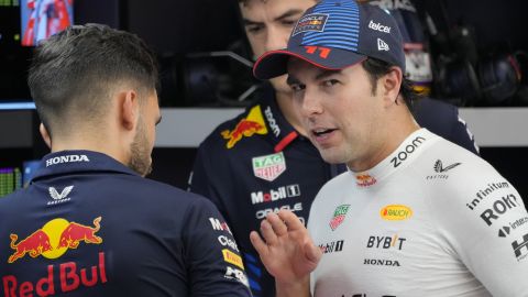 Red Bull driver Sergio Perez of Mexico talks inside their garage during the second practice session of the Singapore Formula One Grand Prix at the Marina Bay Street Circuit, in Singapore, Friday, Sept. 20, 2024. (AP Photo/Vincent Thian)