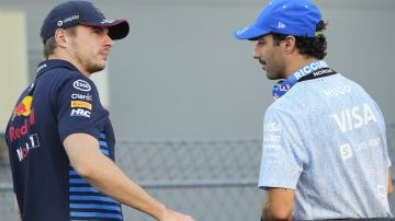 Red Bull driver Max Verstappen, left, of the Netherlands and RB driver Daniel Ricciardo of Australia talk during the drivers parade ahead of the Singapore Formula One Grand Prix at the Marina Bay Street Circuit, in Singapore, Sunday, Sept. 22, 2024. (AP Photo/Vincent Thian)