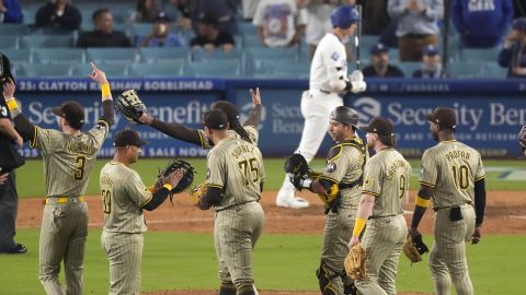 Jugadores de los Padres celebran el triunfo sobre los Dodgers luego de confirmarse un insólito triple play mientras Shohei Ohtani se retira del campo.