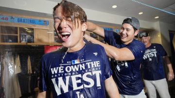 Shohei Ohtani baña con champán a su compatriota Yoshinobu Yamamoto en el vestidor de los Dodgers luego de ganar la División Oeste.