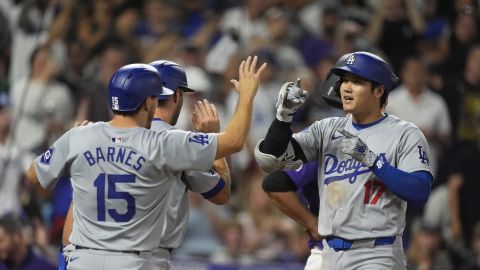 Los Angeles Dodgers' Austin Barnes (15) congratulates Shohei Ohtani (17) who crosses home plate after hitting a three-run home run off Colorado Rockies relief pitcher Anthony Molina in the sixth inning of a baseball game Friday, Sept. 27, 2024, in Denver. (AP Photo/David Zalubowski)