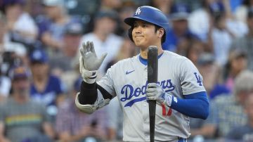 Como es su costumbre en cada partido, Shohei Ohtani saluda con una sonrisa a los jugadores rivales de los Rockies antes de pararse a batear por primera vez el sábado en Colorado.