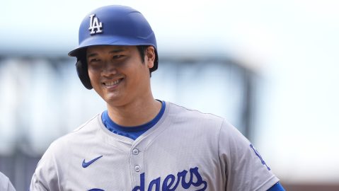 Los Angeles Dodgers' Shohei Ohtani smiles after reaching first base on a single off Colorado Rockies relief pitcher Seth Halvorsen in the eighth inning of a baseball game Sunday, Sept. 29, 2024, in Denver. (AP Photo/David Zalubowski)