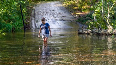 FILE - Teresa Elder walks through a flooded Sandy Cove Drive from Hurricane Helene on Sept. 27, 2024, in Morganton, N.C. (AP Photo/Kathy Kmonicek, File)